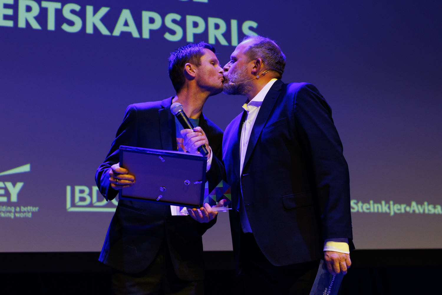 Truls Svendsen får et kyss av prisvinner for årets service- og vertskapspris under Næringslivets Hedersaften 2023 i Steinkjer.